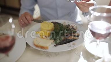在餐馆吃饭的人。 在餐馆吃饭。 海鲜。 吃烤鲭鱼的人用盘子里的土豆